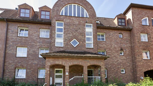 Backstein-Hauseingang Nr. 17 mit überdachtem Vorbau und Halbkreisfenster.